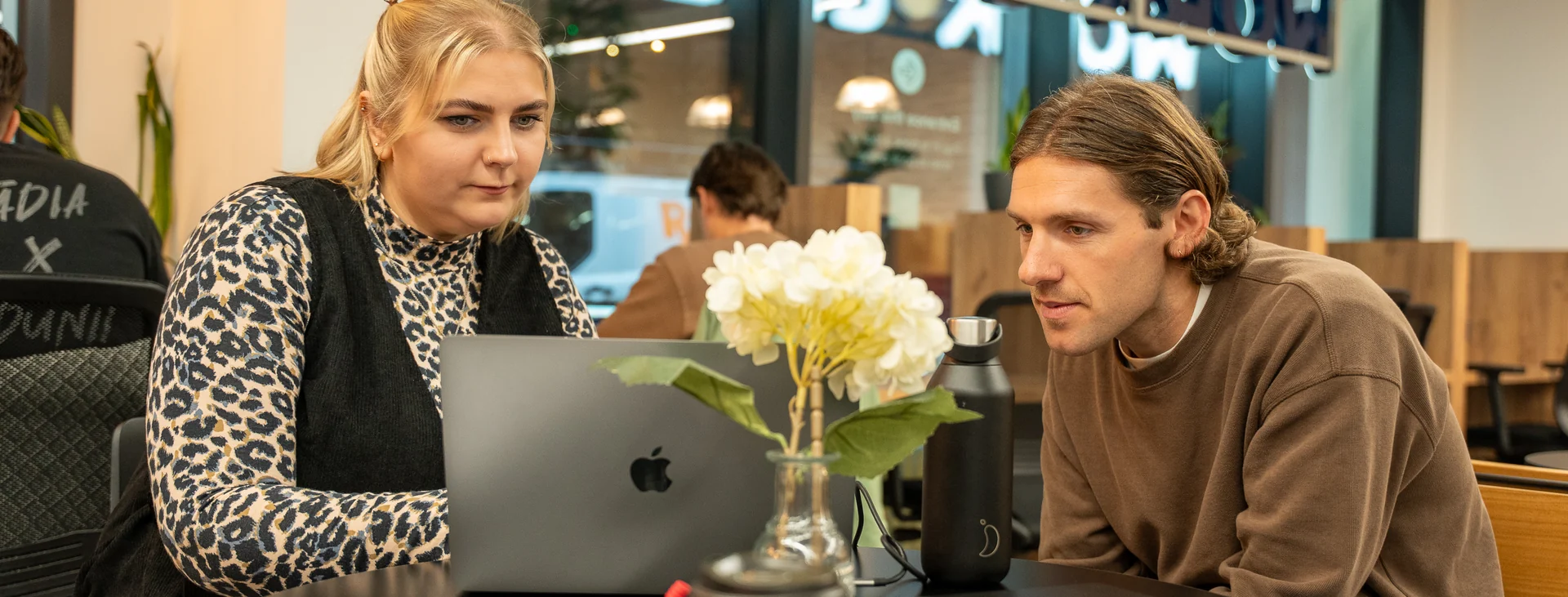 Two colleagues looking at a laptop together in the Leadly office