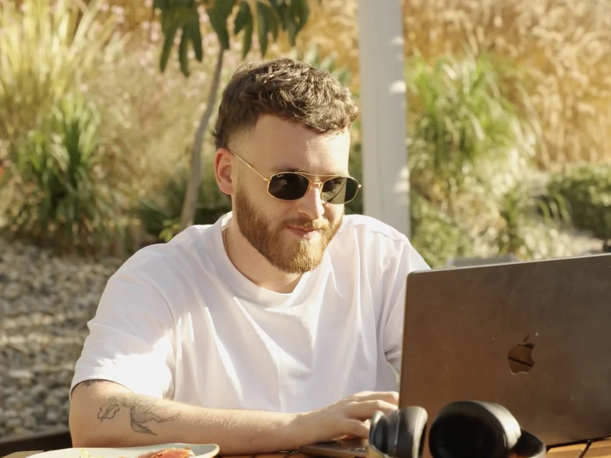 A team member working on a laptop outdoors in the sun