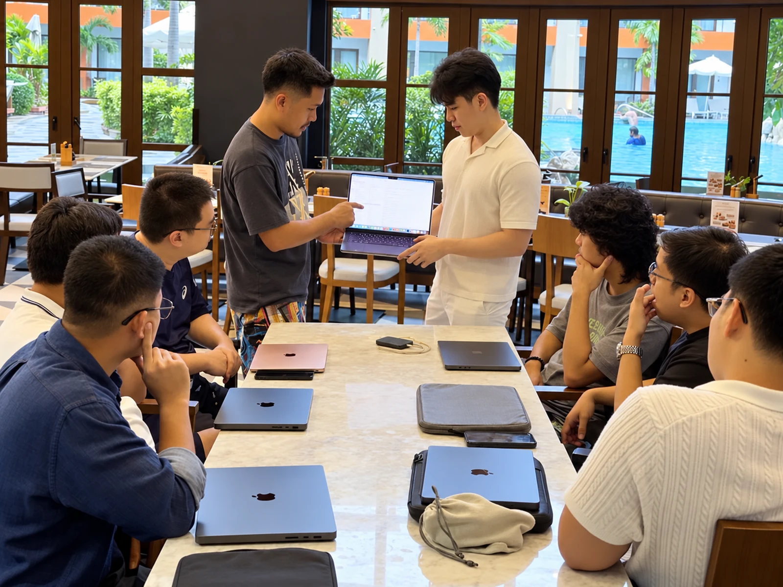 Part of the Leadly team working together around a table with laptops