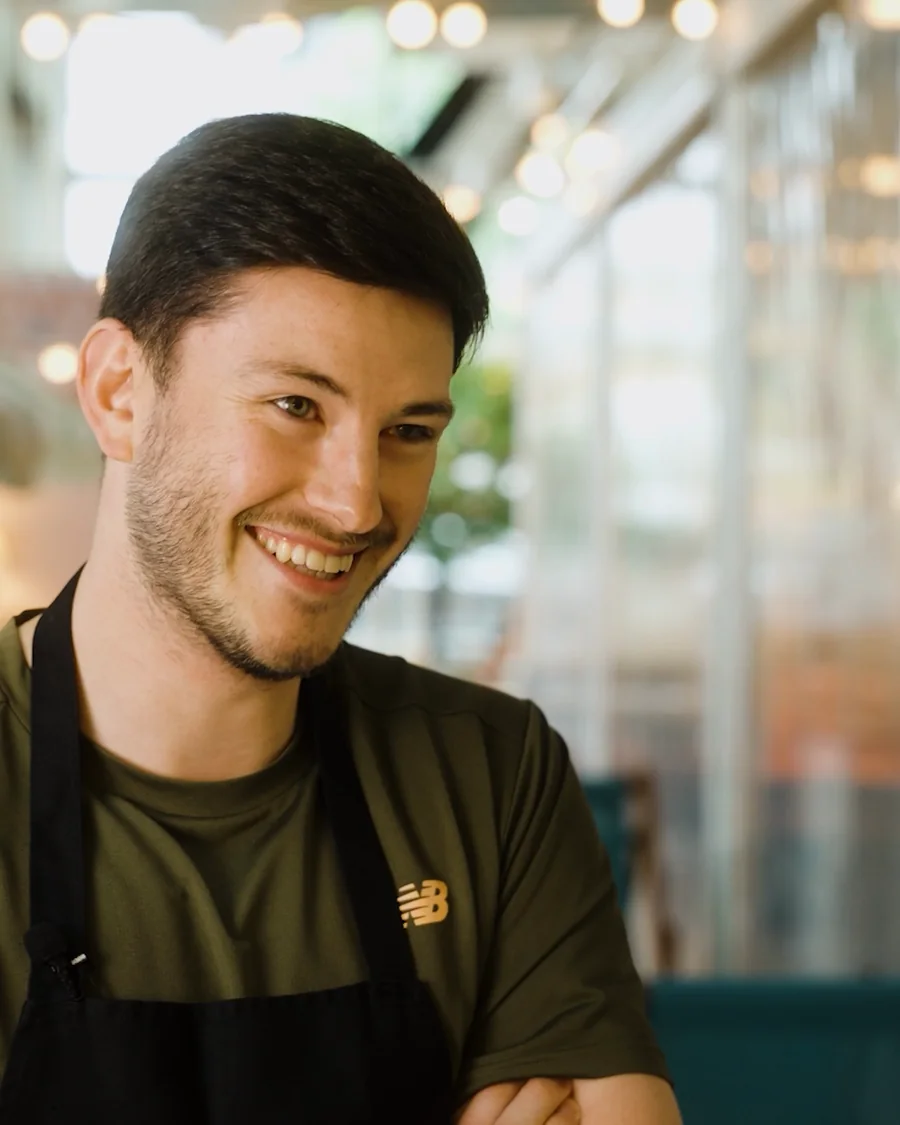 A colleague smiling in an apron at the Leadly bake-off