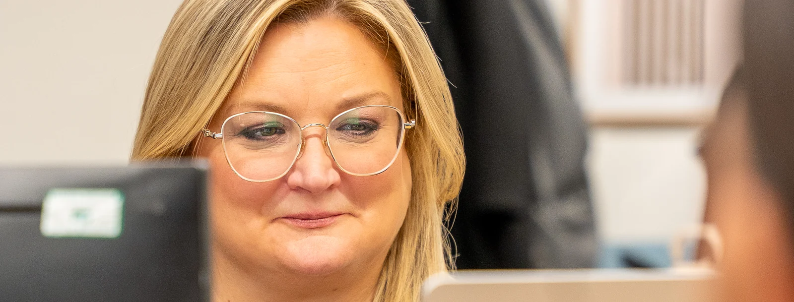 A colleague smiling at her desk in the Leadly office
