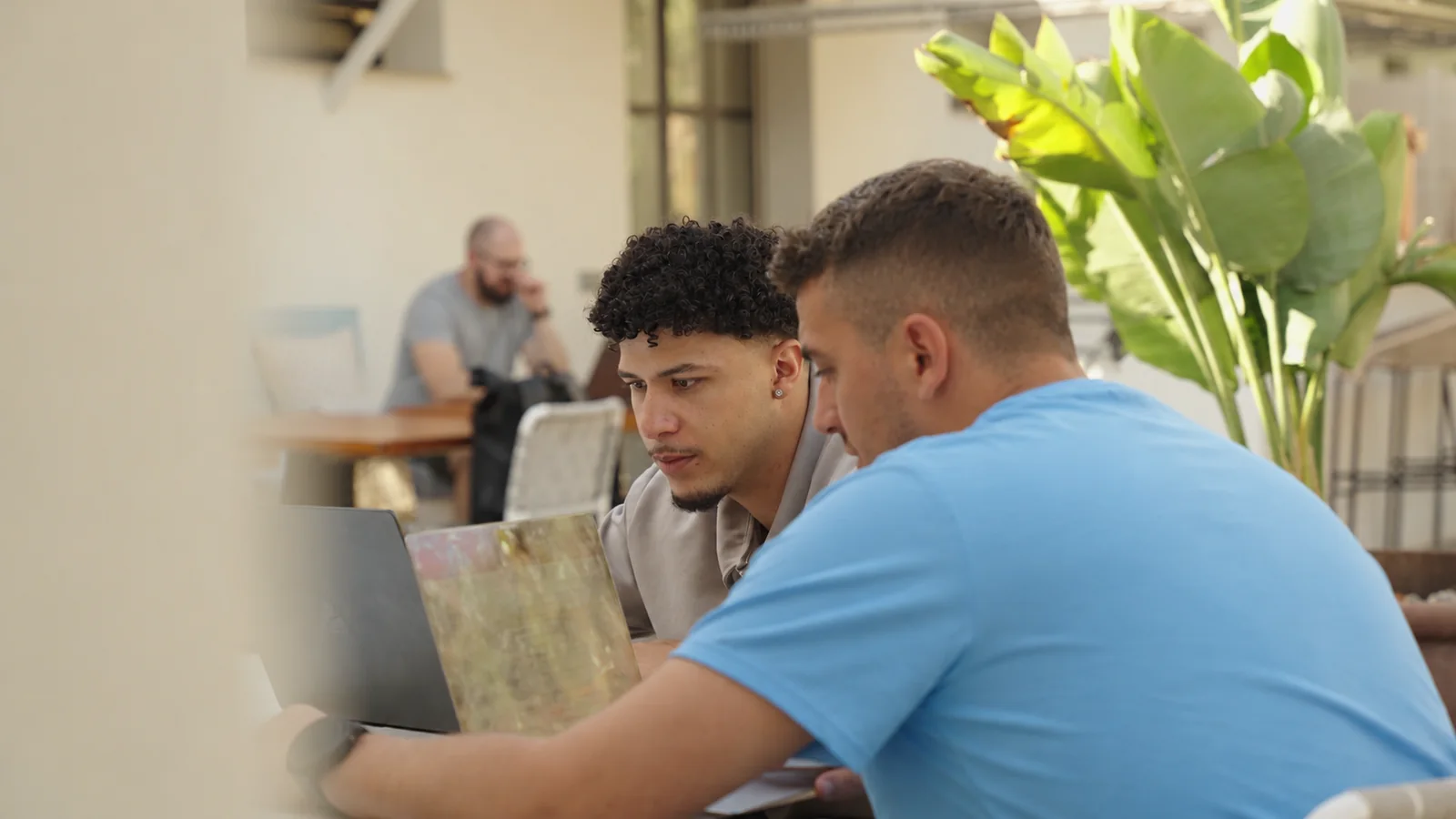 Two colleagues working through an idea together at a laptop